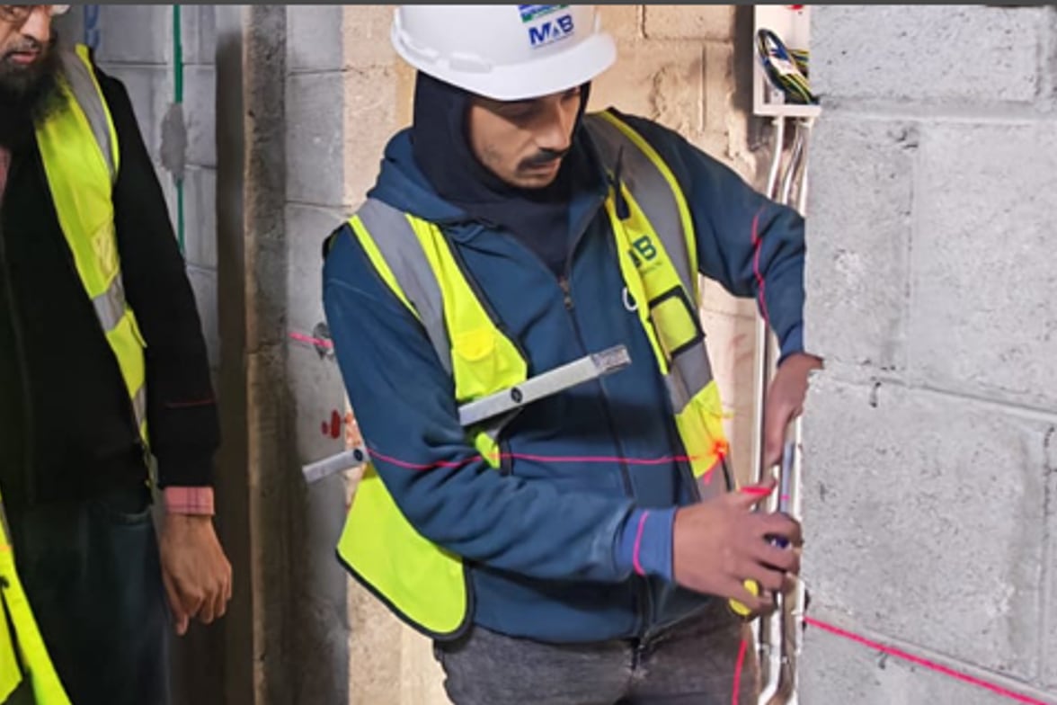مهندس من ماب الاتحاد يحدد مسارات التمديدات في الموقع